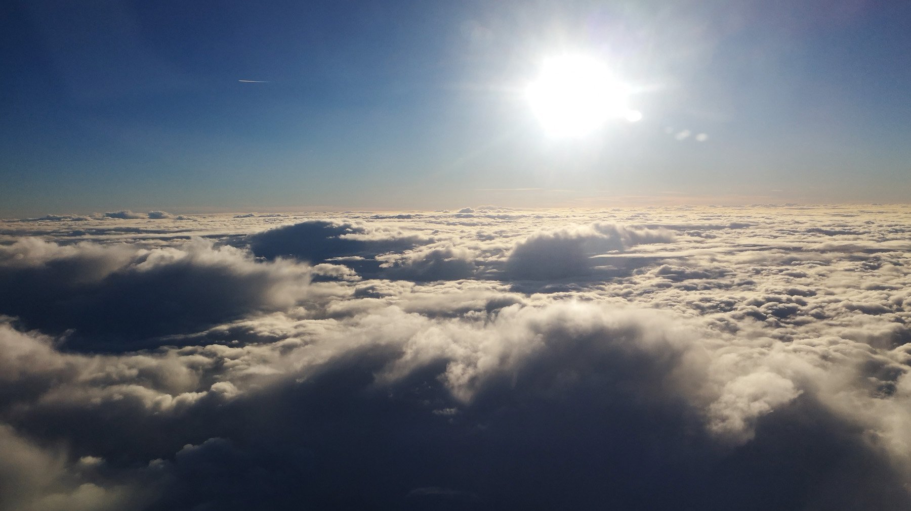Sonne strahlt über einer Wolkendecke