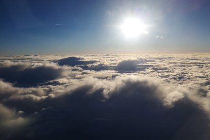 Sonne strahlt über einer Wolkendecke